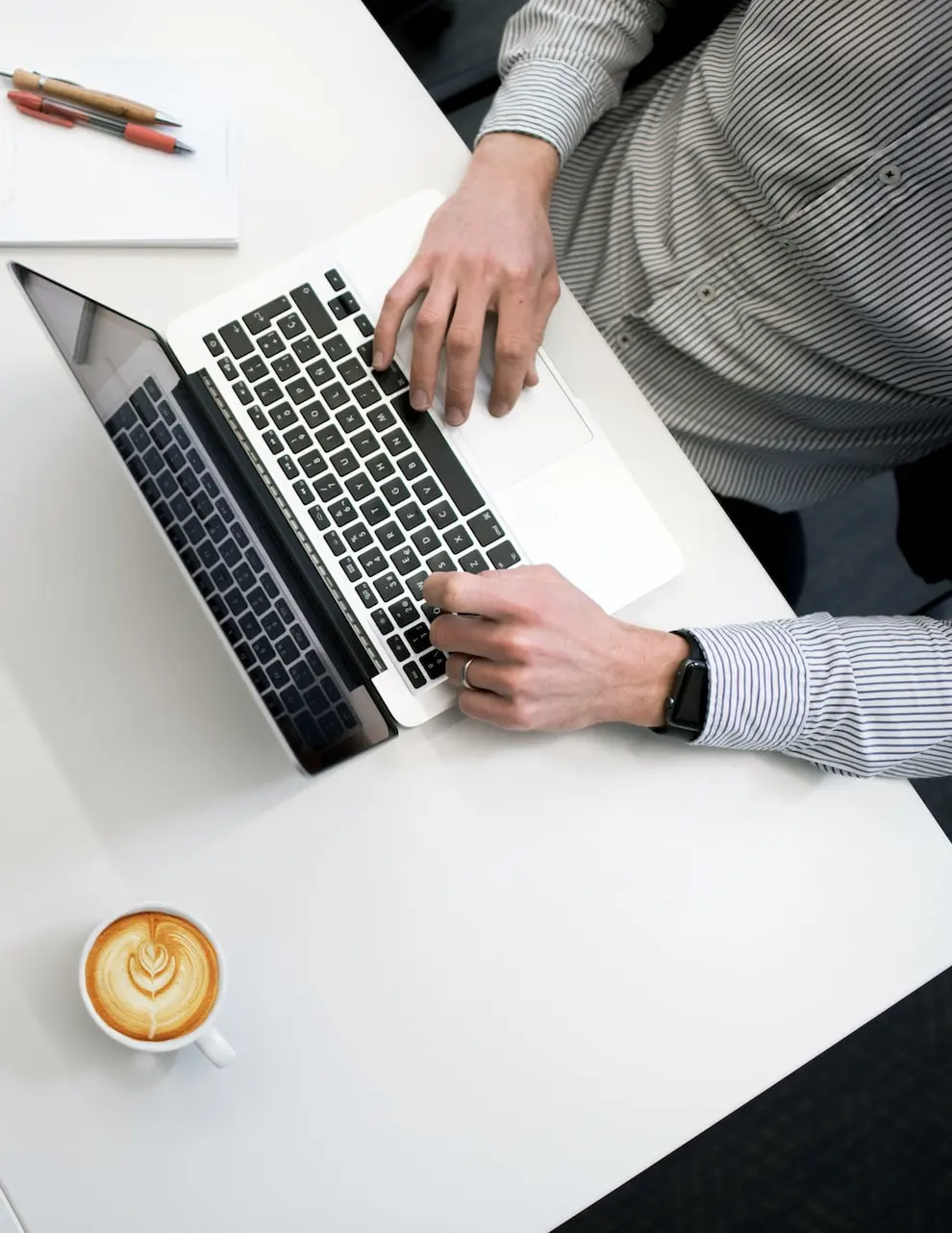 person using laptop on white wooden table